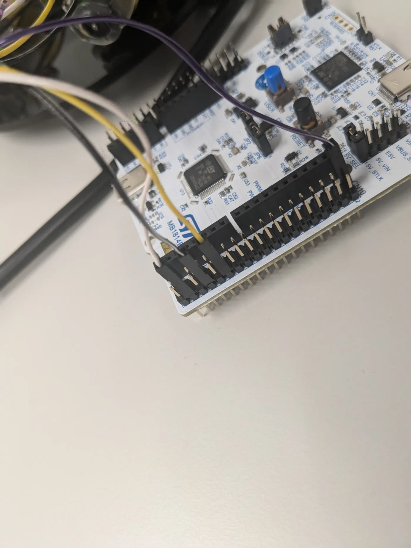 Close-up of the STM32 Nucleo development board with jumper wires running from its pin headers.